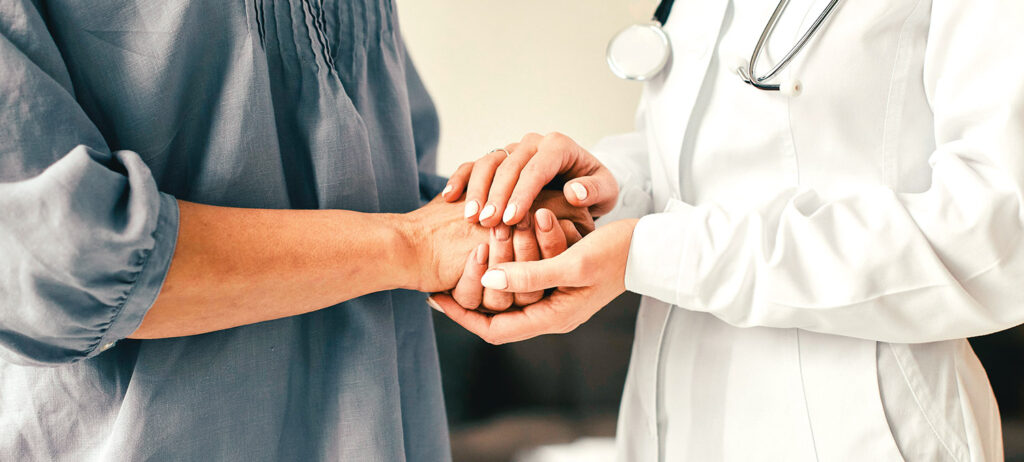 Doctora sujetando las manos de una paciente medicina integral y holística