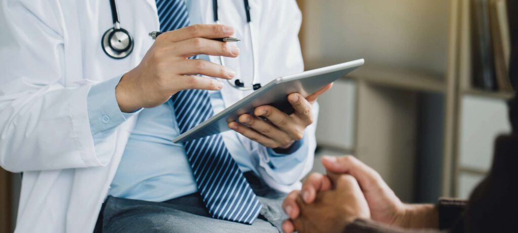 Doctor con ipad en su mano hablando con paciente de psiquiatría y oftalmología en consulta médica