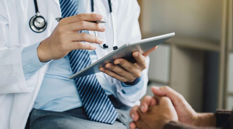 Doctor con ipad en su mano hablando con paciente de psiquiatría y oftalmología en consulta médica