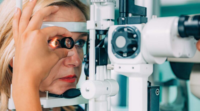 Mujer mediana edad recibiendo examen de los ojos para lente intraocular y miopía alta, con equipo de oftalmología