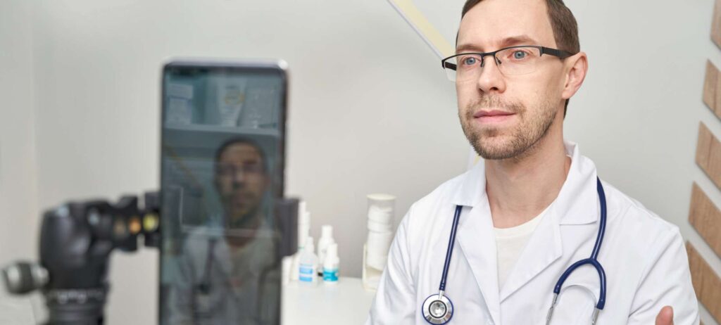 Doctor grabando video con teléfono inteligente para las redes sociales