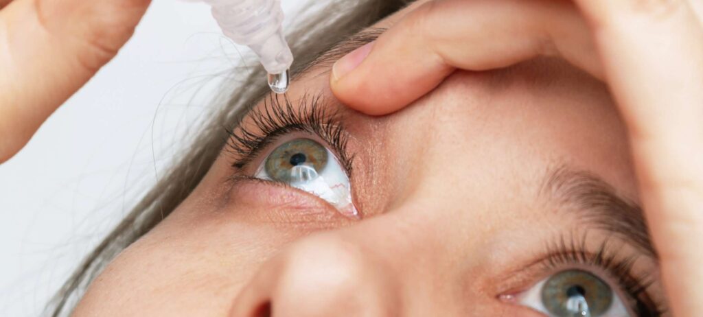 Mujer aplicando gotas para salud visual en su ojo derecho