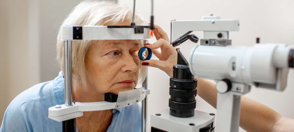 Mujer de la tercera edad durante examen de ojos para estudio de pigmentos maculares