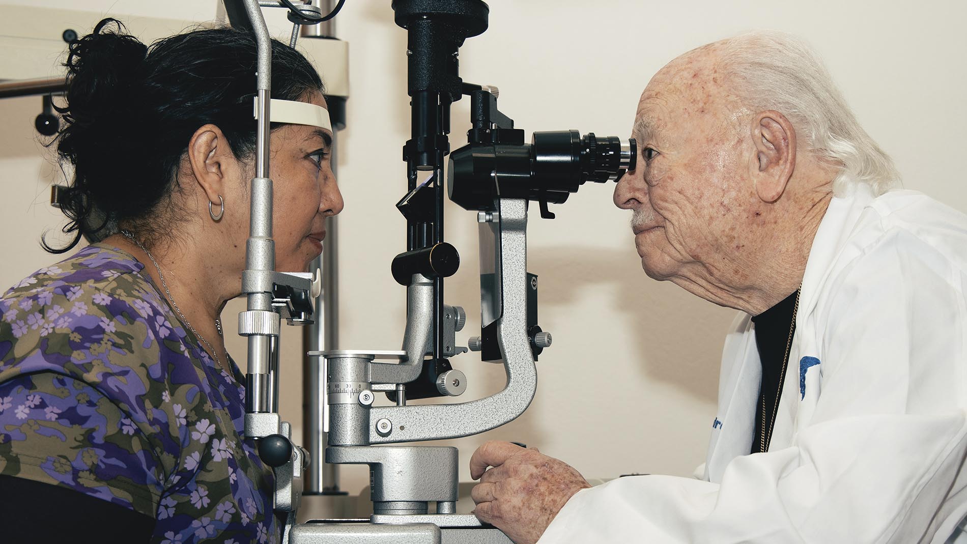 Doctor Alejandro Dalma Kende, oftalmólogo, realizando prueba de la vista a paciente, usando equipo médico de oftalmología