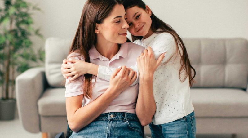 Niña abrazando a mujer joven de forma afectuosa