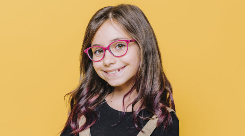niña con lentes sonriendo a la cámara