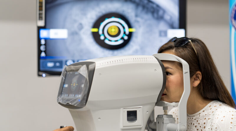 Mujer recibiendo un examen oftalmológico con equipo automatizado, mientras en el monitor se proyecta una imagen ampliada del ojo. Representa el uso de inteligencia artificial en la detección de enfermedades visuales como glaucoma y retinopatía diabética.
