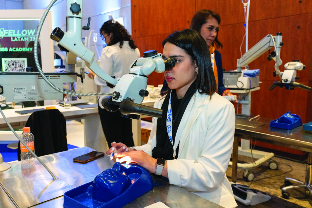 Doctora oftalmóloga joven, usando bata médica mientras realiza práctica con equipo médico moderno de oftalmología, durante el evento Oftafellow 2023