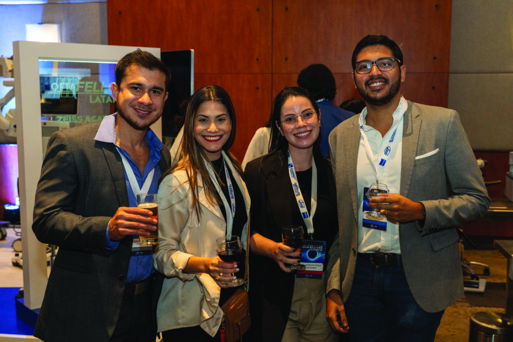 Doctores y doctoras jóvenes especializados en oftalmología, posando para la cámara, sosteniendo copas en la mano, durante evento oftafellow 2023