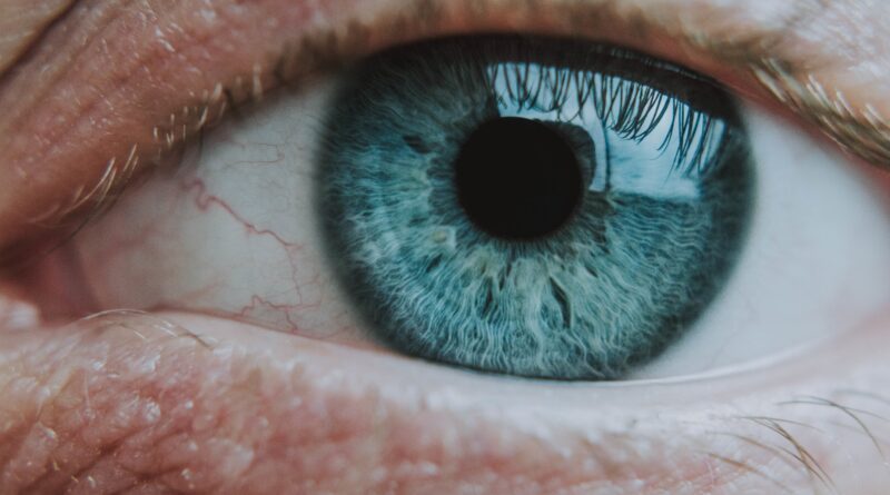 Close up vertical de una ojo color azul de una persona mayor con una pupila normal